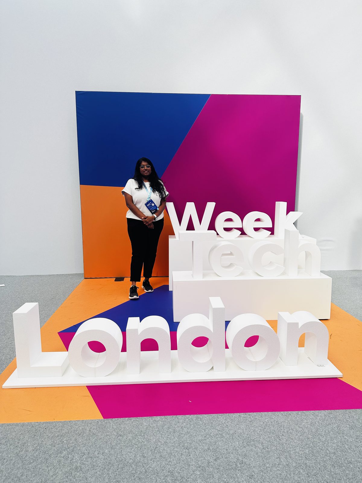 Swaathy in front of the giant London Tech Week letters at Olympia